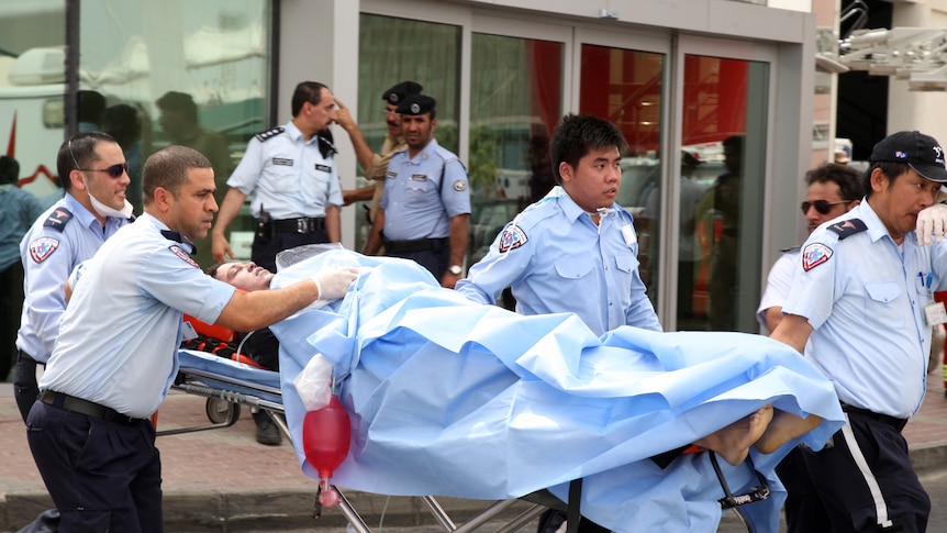 A survivor receives medical care outside Doha's Villaggio Mall after a fire broke out inside a shopping centre.