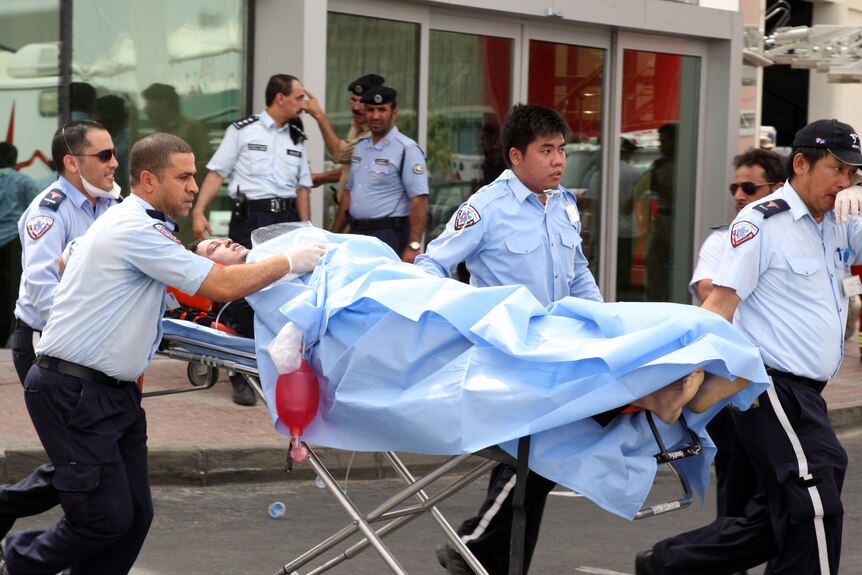 A survivor receives medical care outside Doha's Villaggio Mall after a fire broke out inside the shopping centre.