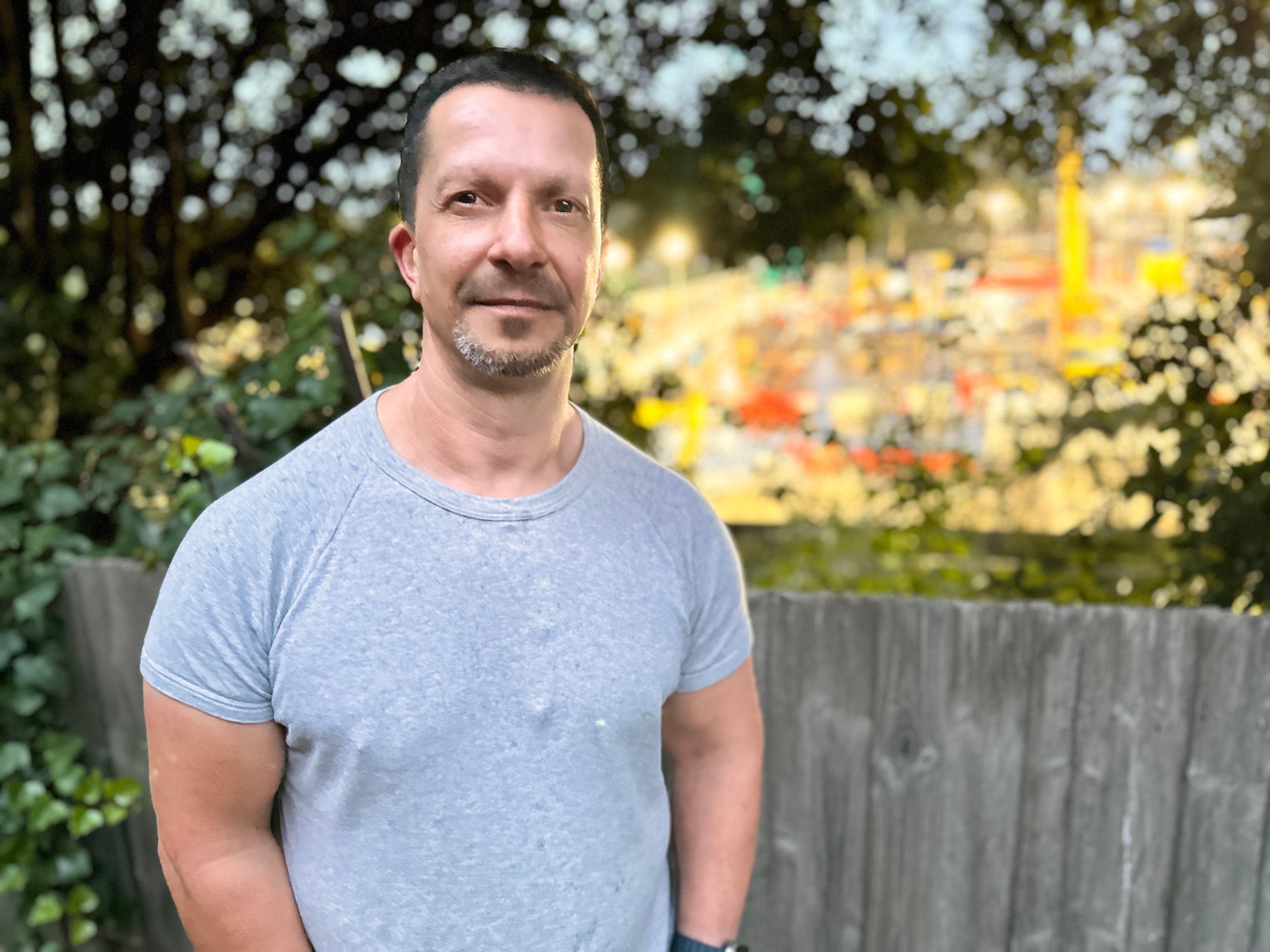 Bulleen resident standing in backyard, back-dropped by a busy construction site