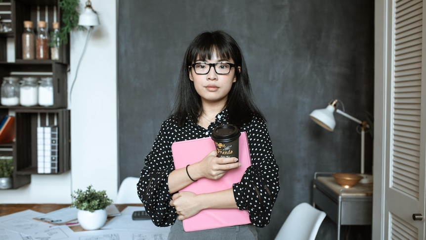 Woman looking apprehensive at work in a story about regaining confidence after being in a toxic workplace.