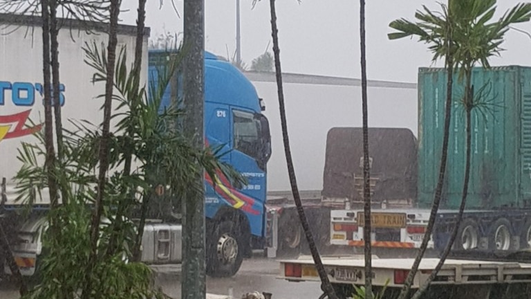 Numerous trucks waiting in rain at a service station in Townsville.