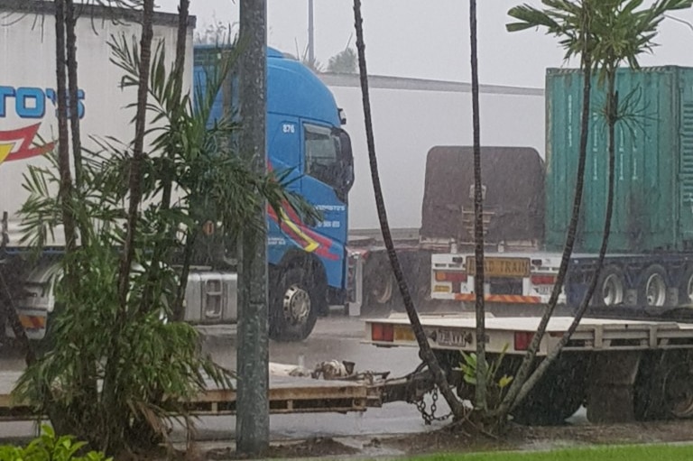 Numerous trucks waiting in rain at a service station in Townsville.