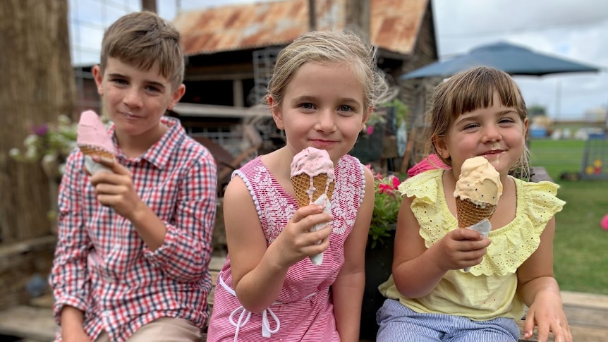 Three children hold dripping ice cream cones.