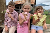 Three children hold dripping ice cream cones.