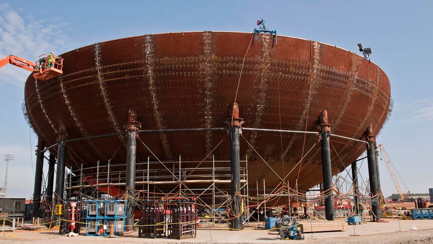 Workers construct a containment vessel bottom head at a planned nuclear power reactor