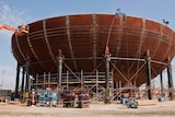 Workers construct a containment vessel bottom head at a planned nuclear power reactor