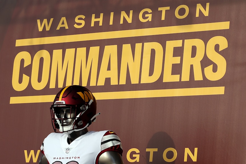 A mannequin wearing an American football jersey and helmet stands in front of a sign that reads "Washington Commanders" 