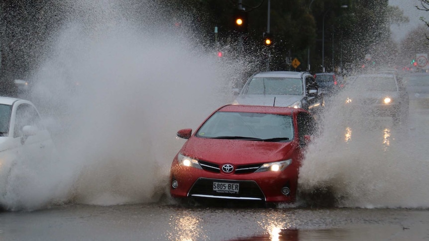 Cars go through water across Hutt Road.