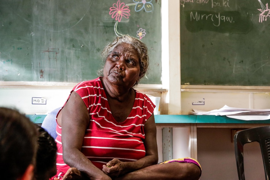 Yolngu elder Elaine Lawurrpa Maypilama is listening during a doula class. She wears a red shirt.