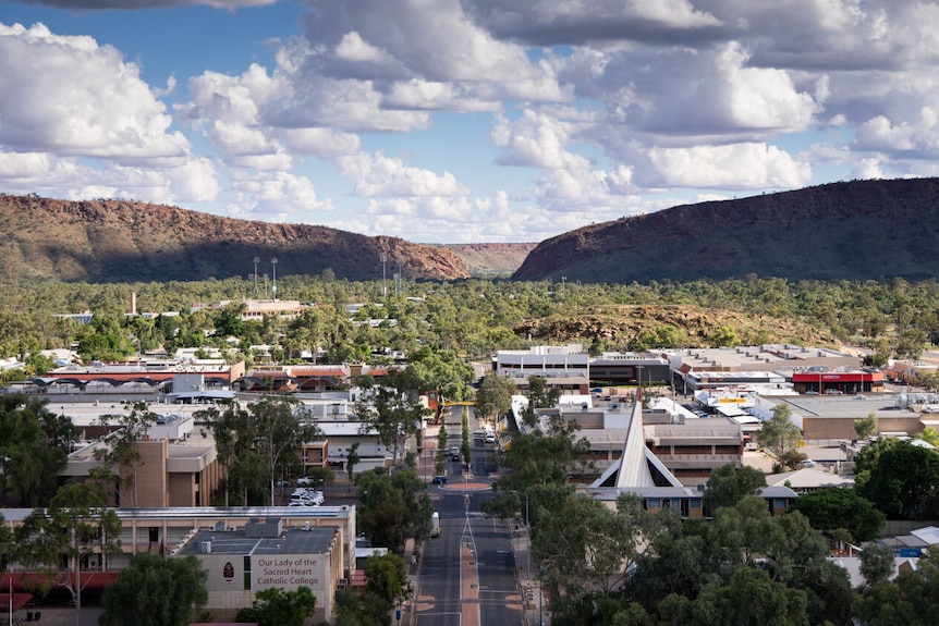 Wide aerial shot of Alice Springs street with bush and mountains in background 