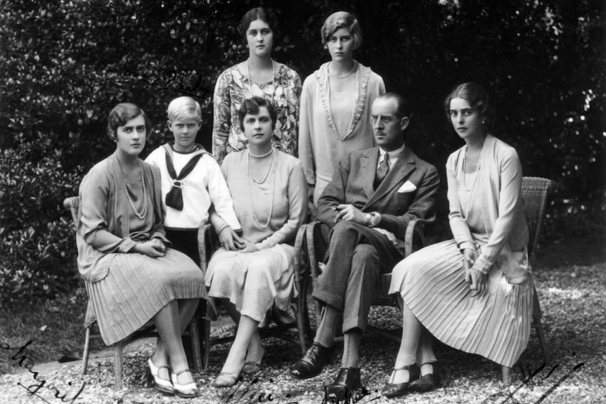 A photograph of a family, with two women standing at the back and three women, a young boy and a man sitting at the front.