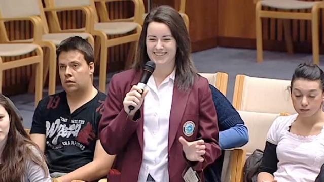 Smiling student stands with microphone