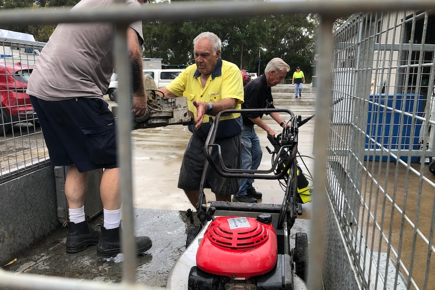 Men unloading tools from a trailer.