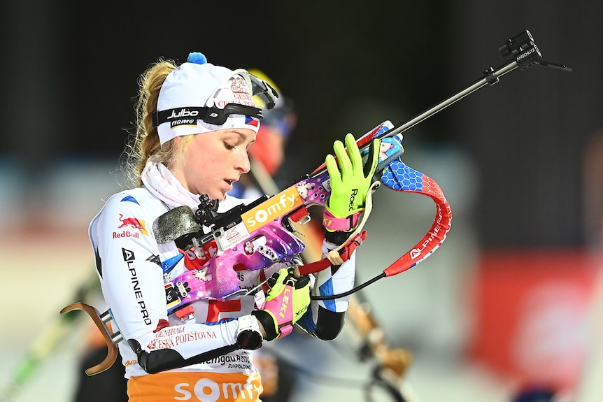 Marketa Davidova looks at her rifle, which has pink unicorns on it