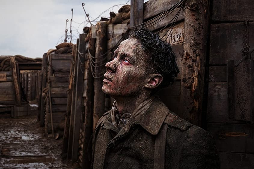 A still from the 2022 film All Quiet On The Western Front showing a man in a trench looking upwards