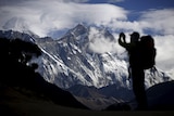 A tourist is silhouetted as he takes pictures of Mount Nuptse in the Everest region. 