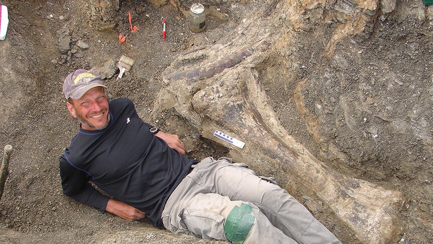 Palaeontologist Kenneth Lacovara of Drexel University stands beside the 'discovery piece' of Dreadnoughtus schrani.