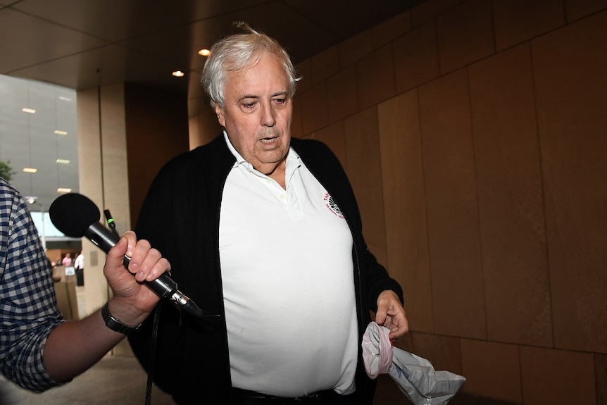 Businessman and former federal MP Clive Palmer holds a sick bag as he arrives back at the Federal Court.