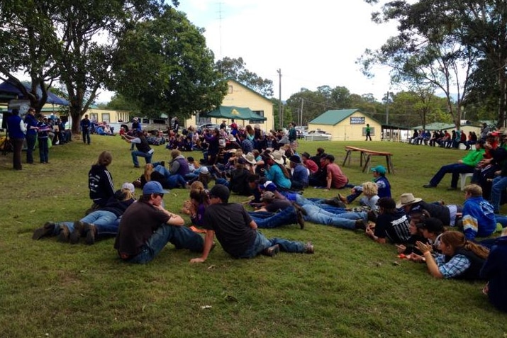 A large group of students sitting on the ground.
