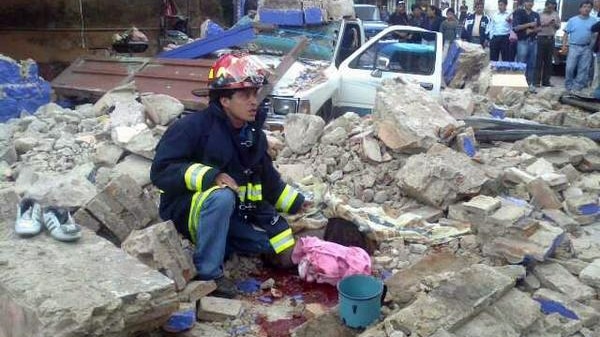 Rescue worker sorts through Guatemala City quake rubble