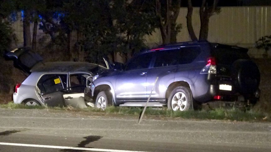 Two cars on the side of the road after a head-on collision.