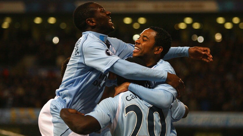 Felipe Caicedo of Manchester City is mobbed by team mates Shaun Wright-Phillips (L) and Robinho