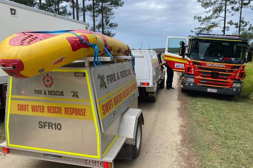 A rescue trailer and a fire truck in a coastal location.