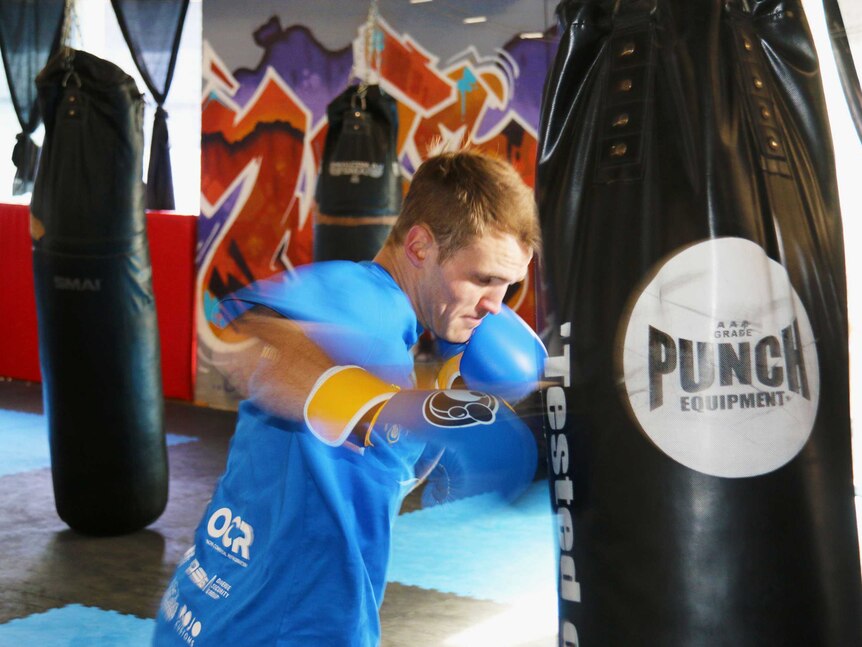 Boxer David Toussaint takes a swing at a punching bag.