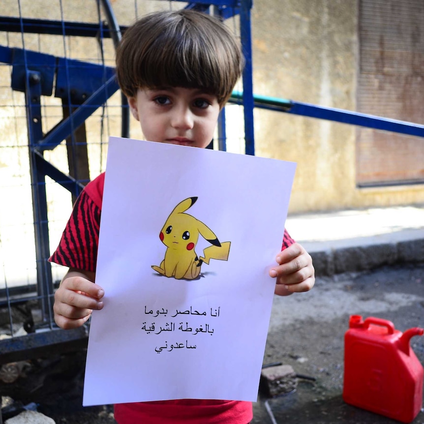 Syrian boy holds sad Pikachu