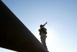 British soldier standing on oil pipe in Basra, Iraq