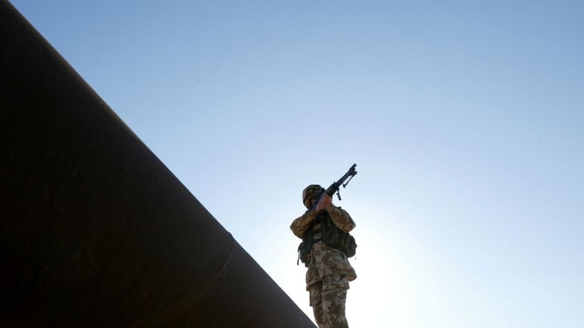 Progress in Basra...a member of the British army climbs on an oil pipe in 2005.