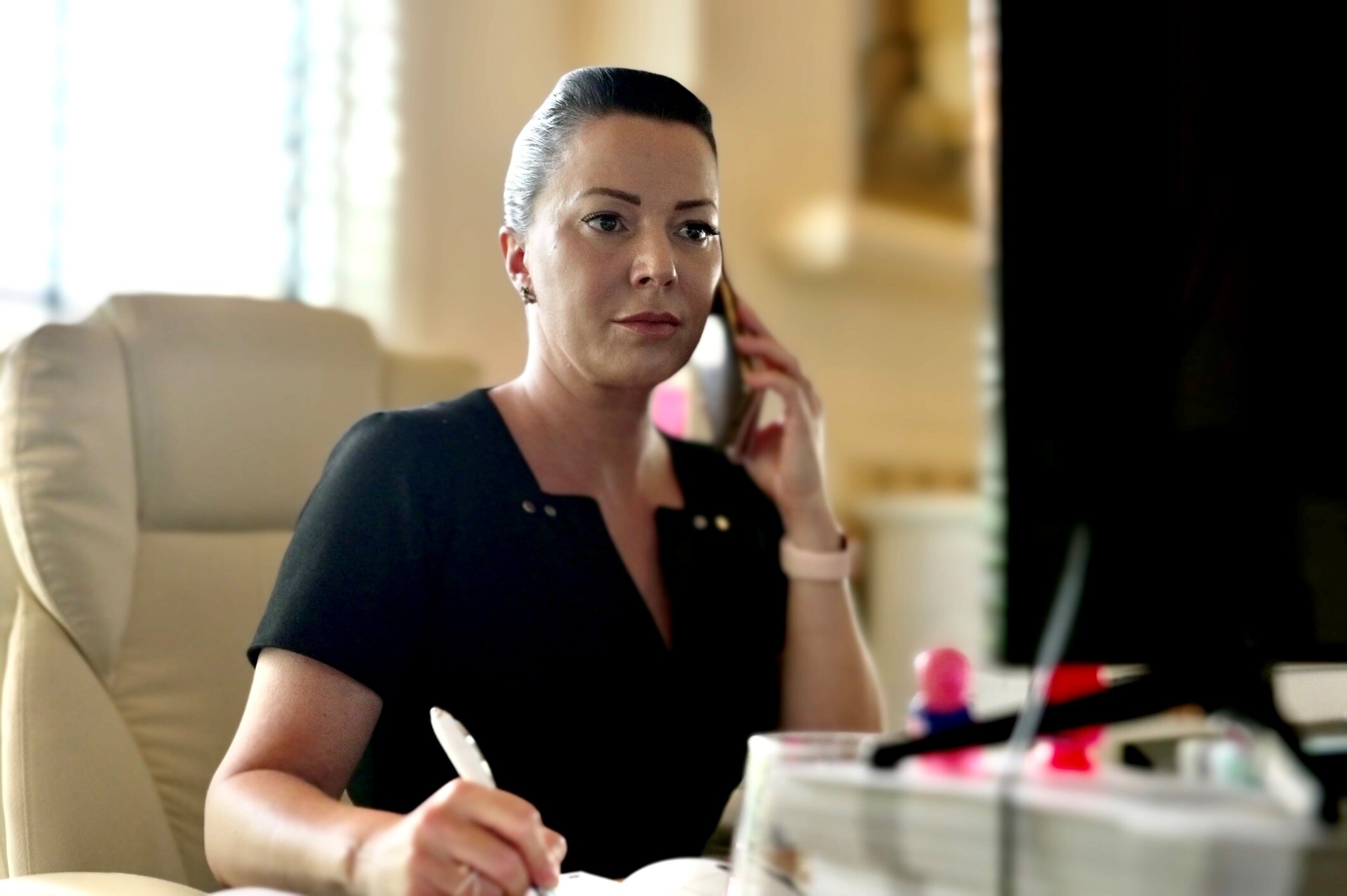 Victoria Coster, founder of Credit Fix Solutions, takes notes while talking on the phone.