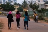 A motorist rides past young Indian girls in Bangalore.