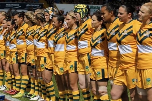 Australian Women's Rugby League team standing side by side in uniforms on the field in UK for the World Cup.