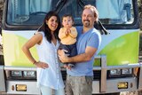 Kevin Craft, his wife Cristina and son Marco stand in front of a bus that serves as their home.