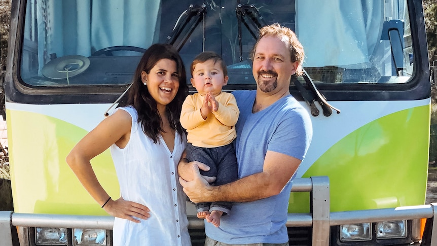 Kevin Craft, his wife Cristina and son Marco stand in front of a bus that serves as their home.