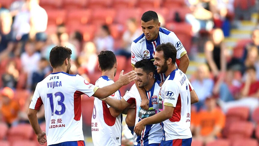 Newcastle Jets players celebrate a goal against the Brisbane Roar at Lang Park on October 22, 2017