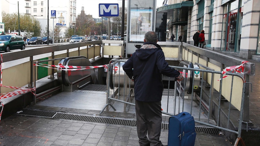 A man waits outside a shutdown Metro station in Brussels
