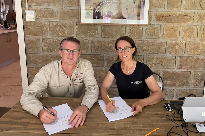 A man and a woman signing documents