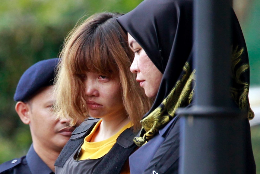 Malaysian police escort suspect Doan Thi Huong.