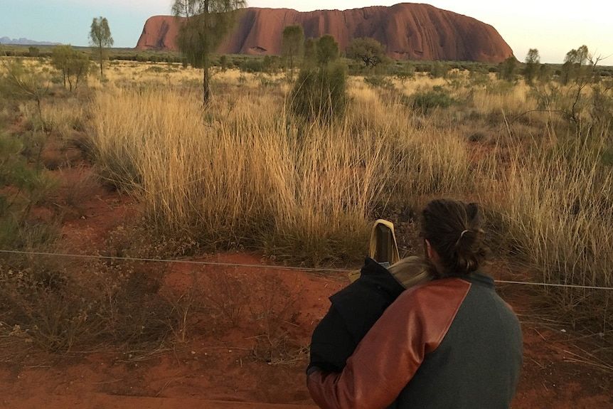 Alex and his two-year-old daughter Paige look out at Uluru.