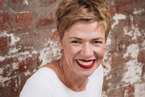 Woman wearing white smiles for the camera.