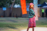 an Indigenous woman poses on a modelling runway