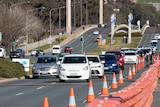 cars drive down Commonwealth Avenue with roadworks.