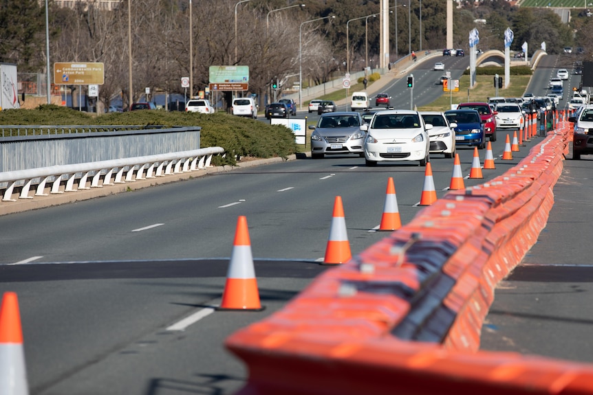 cars drive down Commonwealth Avenue with roadworks.