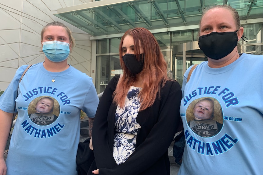 Three women wearing face masks stand outside a Perth court building.