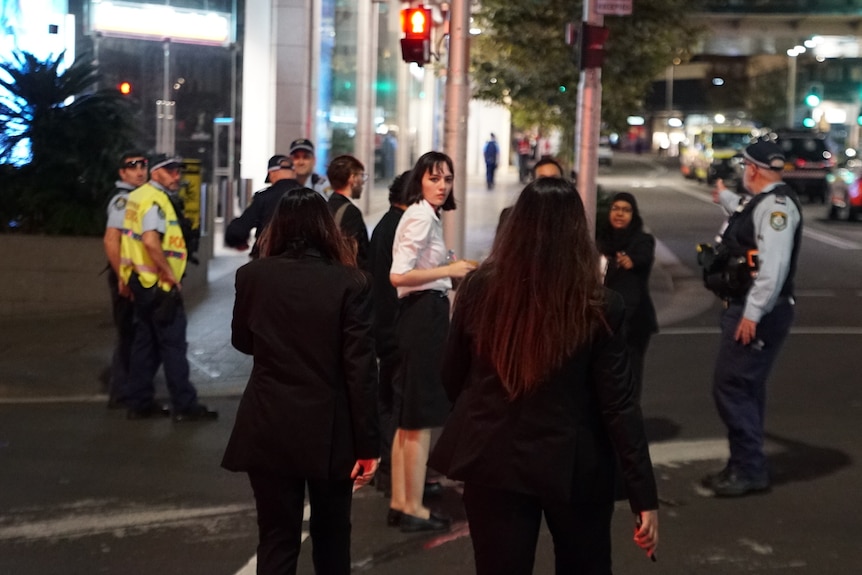 People stand on the street at Bondi Junction westfield after the stabbing incident on saturday april 13 2024