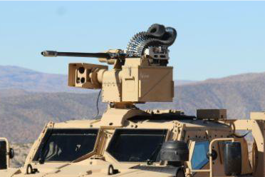 A closeup of a weapons system on top of a sand coloured army vehicle