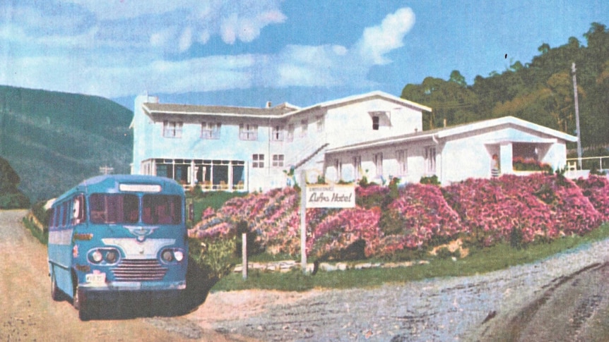 Colour photo from a newspaper of the Lufra Hotel with a bus outside