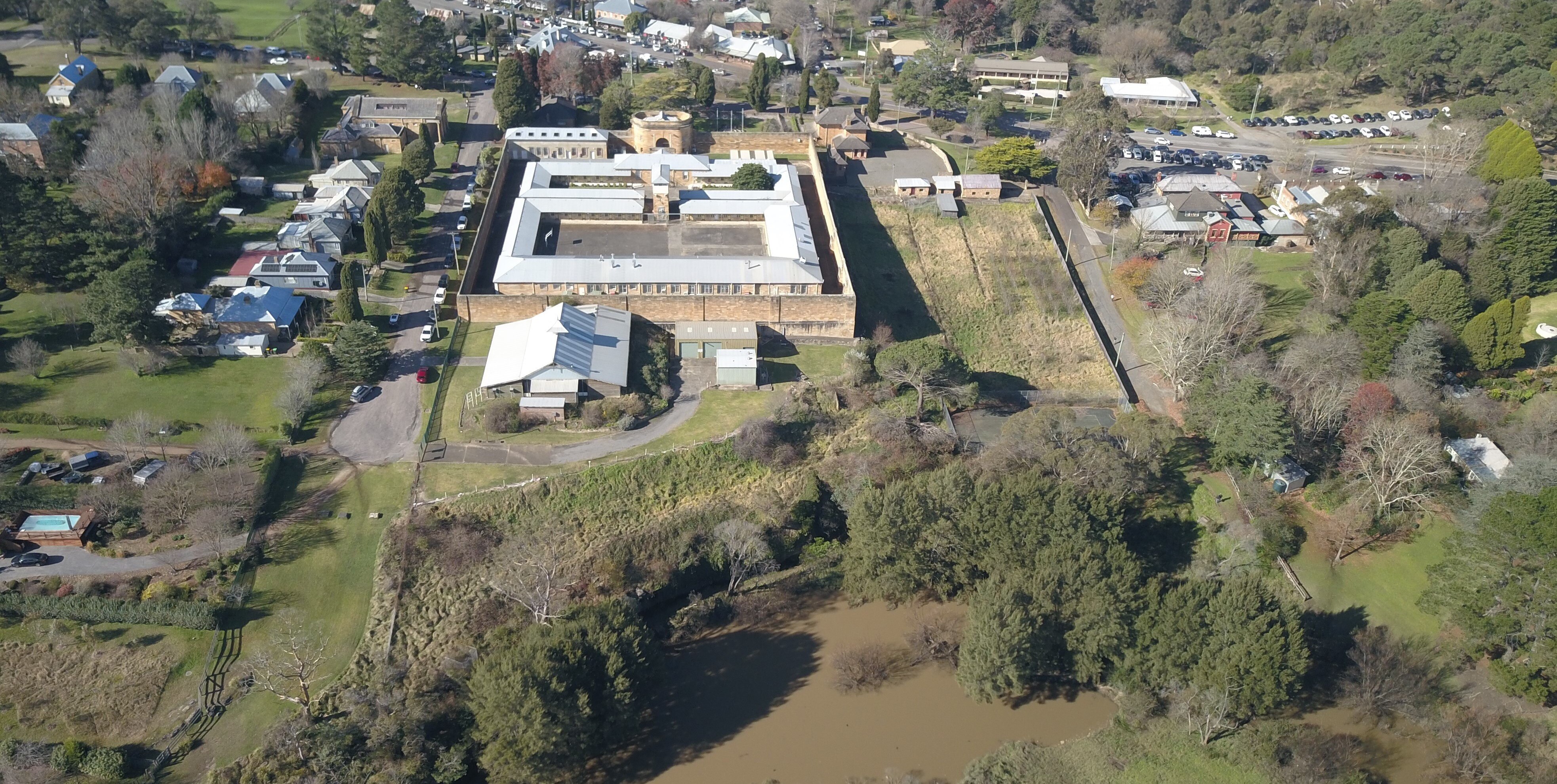 Aerial view of heritage building surrounded by small buildings and trees